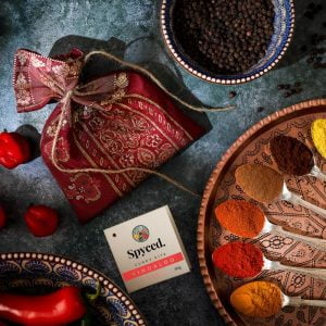A Spyced gift bag and colourful Vindaloo spices displayed in teaspoons